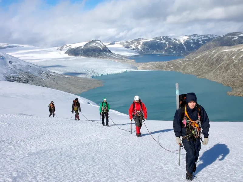 a group of people riding skis on a snowy mountain