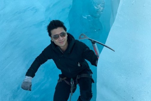 a man riding a snowboard down a snow covered slope