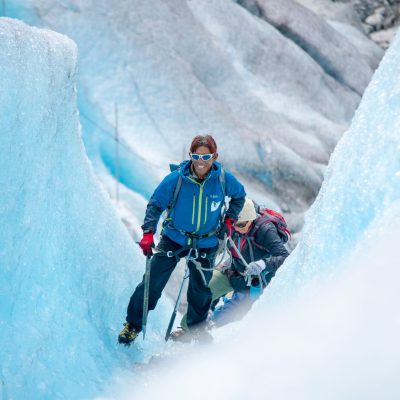 a man climbing up a snow covered glacier