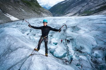 man ice climbing on glacier