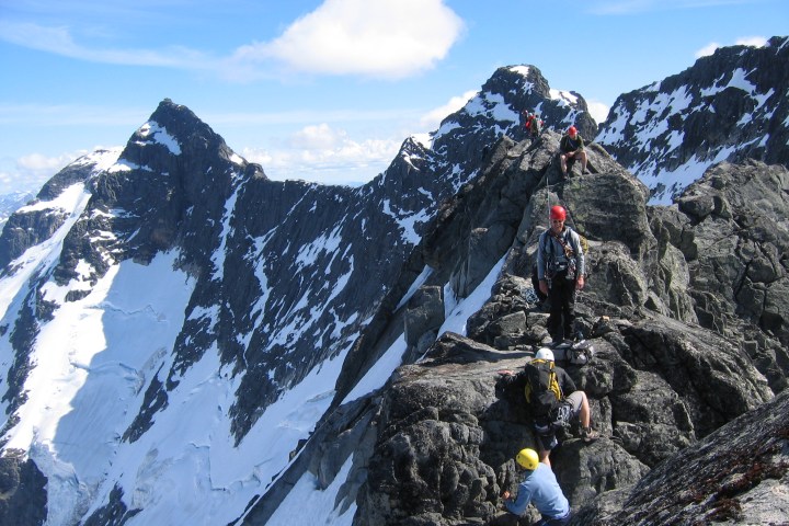 a group of people standing on top of a snow covered mountain