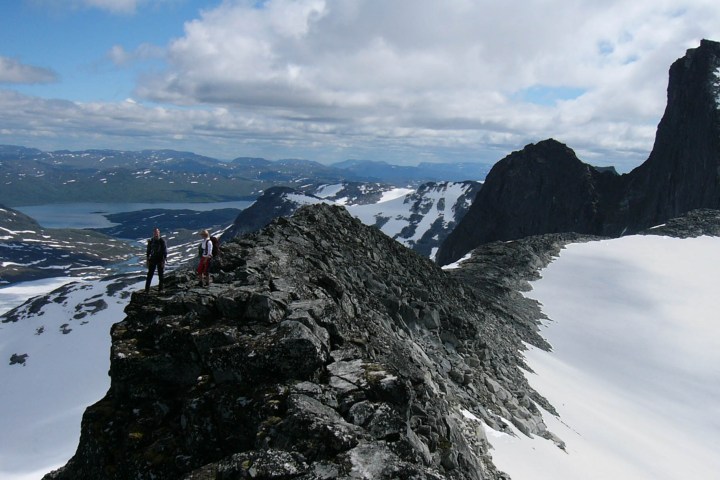 a man standing on the side of a snow covered mountain