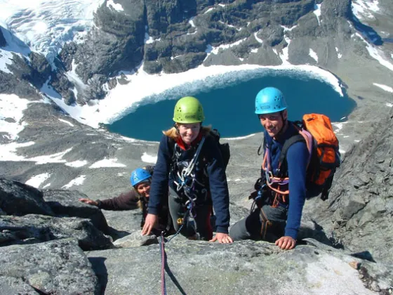 a group of people sitting on a rock in the snow