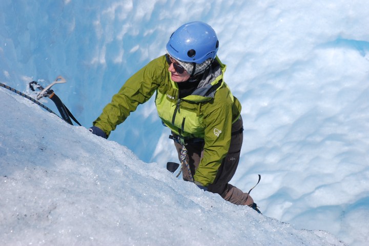 a man riding a snowboard down a snow covered slope