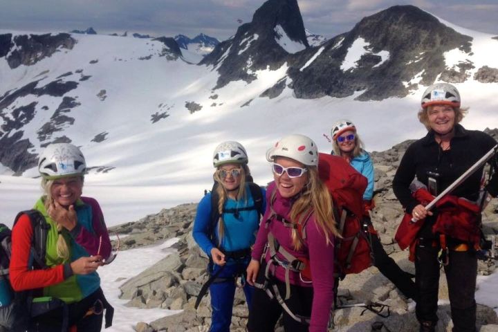 a group of people standing on top of a snow covered mountain