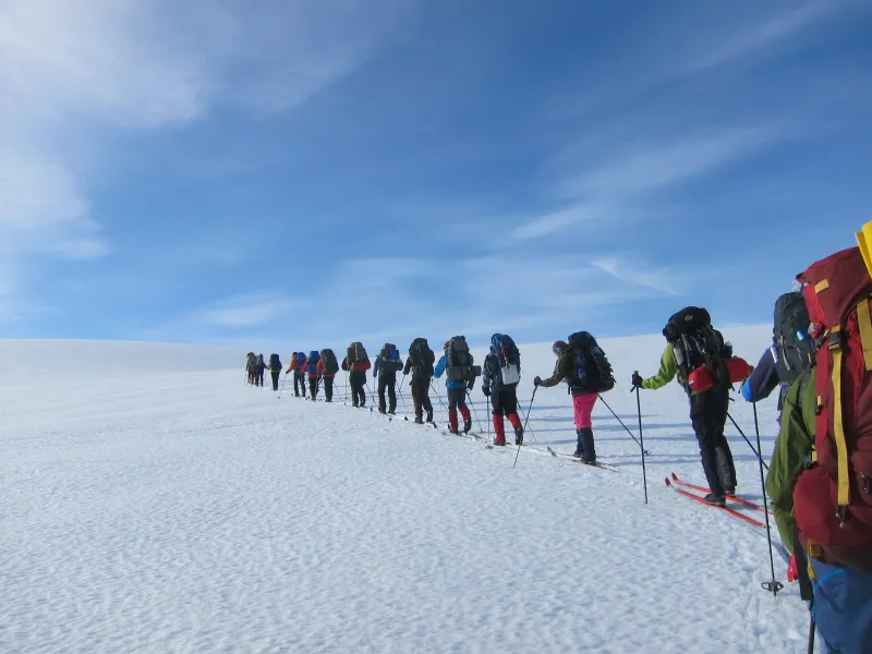 a group of people riding skis on top of a snow covered slope