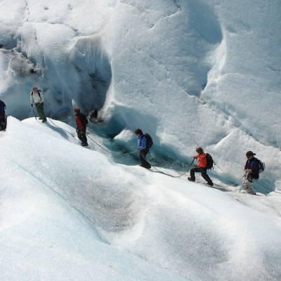a group of people walking on the glacier