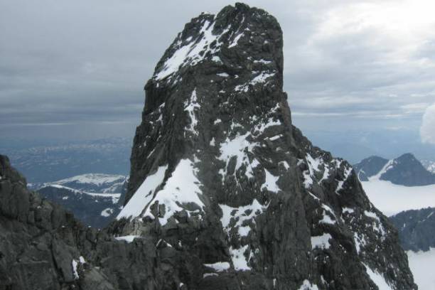 a man standing on the side of a snow covered mountain