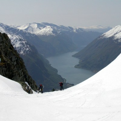 a man riding skis down a snow covered mountain