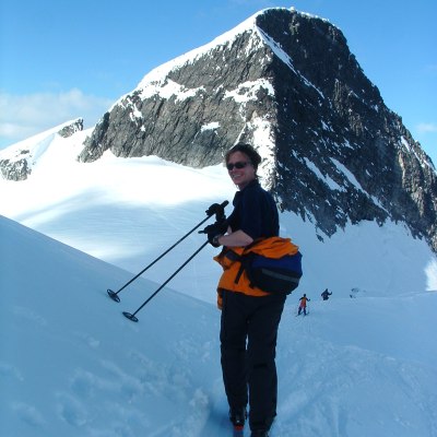 a man riding skis down a snow covered mountain